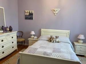 due orsacchiotti seduti su un letto in una camera da letto di Bastide Bellevue a Gaudonville