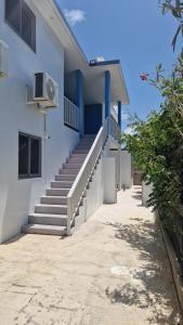a white building with blue steps and a staircase at Viemerci veronica suite 9b in Santa Catharina