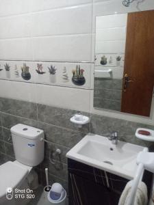 a bathroom with a toilet and a sink and a mirror at Maison d'hôtes Oujda in Oujda +1 photo
