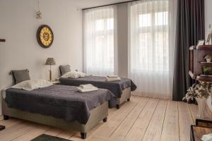 a bedroom with two beds and a clock on the wall at Apartamenty na Starówce in Kalisz
