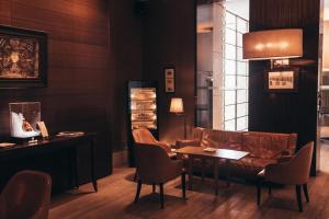 a living room with a couch and a table and chairs at InterContinental Genève by IHG in Geneva