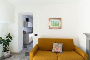 a living room with a yellow couch and a kitchen at Appartamento Lìelà in Millesimo