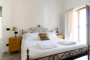 a bedroom with a white bed with two towels on it at Appartamento Lìelà in Millesimo