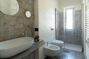 a bathroom with a tub and a toilet and a sink at Appartamento Lìelà in Millesimo +19 photos