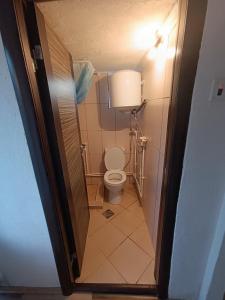 a small bathroom with a toilet in a hallway at Markoski Basement in Kruševo