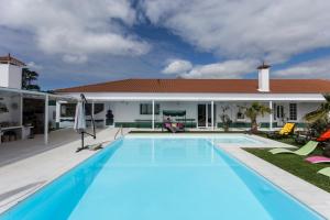 a swimming pool in front of a house at Quinta de Santa Bárbara Casas Turisticas in Lagoa