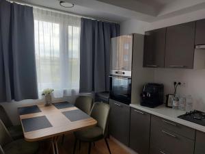 a kitchen with a wooden table and a table and chairs at New Kelly Apartment in Levoča