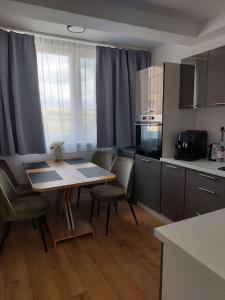 a kitchen with a table and chairs in a room at New Kelly Apartment in Levoča +21 photos