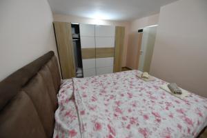 a bedroom with a bed with a flowered blanket at Apartman Poezija in Bajina Bašta