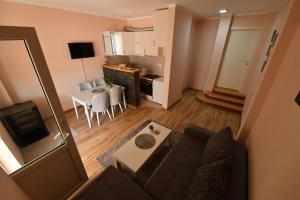 a small living room with a couch and a kitchen at Apartman Poezija in Bajina Bašta