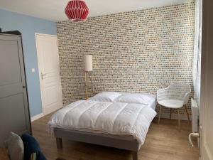 a bedroom with a bed and a brick wall at La Maison Siméon in Amboise
