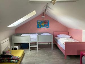 two beds in a room with pink walls at La Maison Siméon in Amboise +5 photos