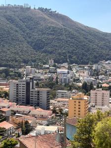 a city with buildings and a mountain in the background at Flat Bambu - Centro - Vista Maravilhosa com Garagem e Elevador in Poços de Caldas