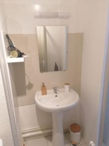 a white bathroom with a sink and a mirror at Le petit coin périgourdin in Bergerac +10 photos
