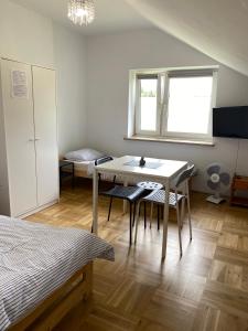 una camera da letto con tavolo, sedie e finestra di Pokoje na Lipowej 2 a Połaniec