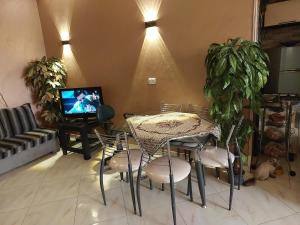 a living room with a table and chairs and a television at شقة اطلالة الأهرامات in Cairo