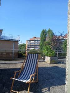 a blue and white striped chair sitting on a balcony at nys willy in Grimbergen