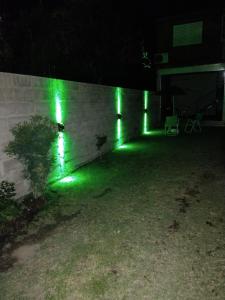 a row of green lights on a wall at night at Depto mina clavero Córdoba zona residencial in Mina Clavero