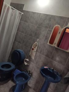 a bathroom with a blue toilet and a sink at Depto mina clavero Córdoba zona residencial in Mina Clavero