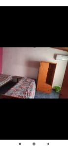 a bedroom with a bed and a wooden cabinet at Depto mina clavero Córdoba zona residencial in Mina Clavero +3 photos