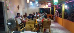a group of people sitting at a table in a restaurant at Bhitarkanika Eco Resort TENT in Righāgarh