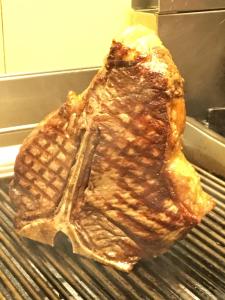 a piece of meat is cooking on a grill at Agriturismo Corte Marani in Badia Calavena