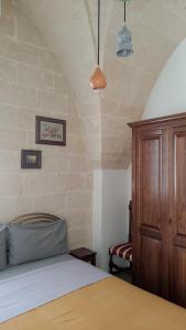 een slaapkamer met een bed en een houten kast bij Casa Vacanze Le Ceramiche in Grottaglie +4 foto's