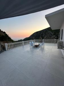 a patio with a table and chairs on a balcony at SWEET HOME 1 in Himare