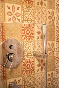 a shower head on a tiled wall in a bathroom at Casa di Minnanni B&B in Santa Teresa Gallura +28 photos