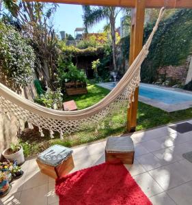 eine Hängematte auf einer Terrasse mit Blick auf einen Hof in der Unterkunft Casa San Isidro pileta jardín parrilla a metros del río in San Isidro