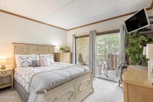 Un dormitorio con una cama grande y un balcón. en Misty Mountain By Beyond Expectations W Hot Tub, en Gatlinburg 45 fotos más