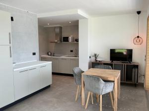 a kitchen with a table and chairs and a television at Villa Regina - Lake Ledro Apartments in Ledro