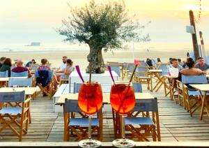 two cocktails sitting on tables and chairs on a boardwalk at La Cabane d'Aselia - petite Maison de Pêcheur in Le Portel +26 photos