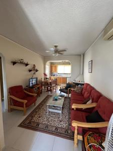 a living room with a red couch and a table at Kuća za odmor Kipar in Pissouri