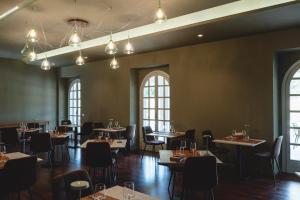a dining room with tables and chairs and windows at Casale Sciarra in Anagni