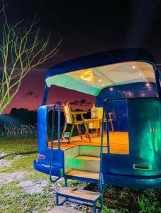 un camper blu con un tavolo e delle sedie al suo interno di Arteco Camp a Baía Formosa