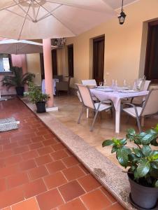 a dining room with a table and chairs and an umbrella at Casa Vacanze Donna Giovanna in Pula