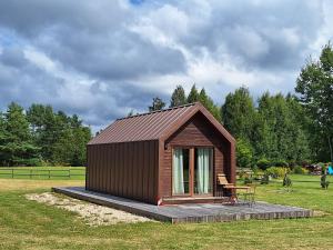 a small cabin with a bench in a field at Rubīni in Jūrkalne