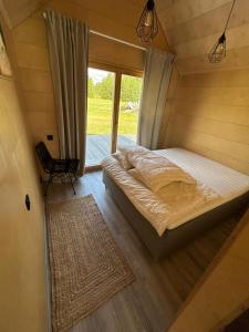 a bed in a small room with a window at Rubīni in Jūrkalne