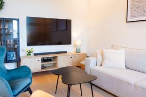 Una sala de estar con un sofá y un televisor. en Carola7, en Szczawno-Zdrój