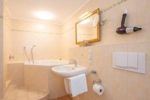 un baño con lavabo y bañera en Insulanerhaus Langeoog Vörn, en Langeoog 5 fotos más