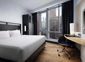 a hotel room with a bed and a desk and window at Hyatt Union Square New York in New York +53 photos
