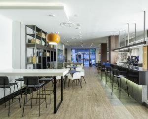 a kitchen and dining room with a table and chairs at Hotel Ilunion Bilbao in Bilbao +32 photos