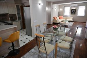 a kitchen and living room with a glass table and chairs at Villa Continental in Bitola