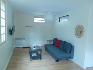a living room with a blue couch and a table at Petite maison avec jardin in Montcaret