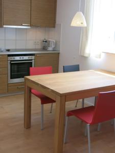a kitchen with a wooden table and red chairs at Zentrales 2-Zimmer Apartment in Tübingen +11 photos