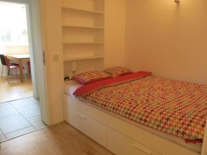 a bedroom with a bed and shelves and a table at Zentrales 2-Zimmer Apartment in Tübingen
