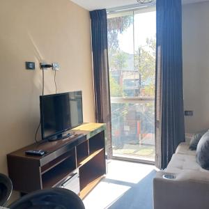 a living room with a tv and a large window at Aparments Av La Paz in Arequipa