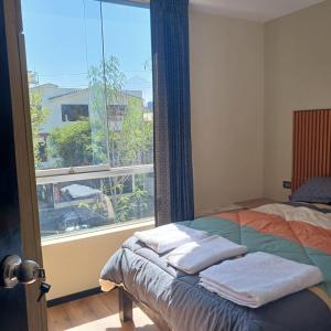 a bedroom with a bed and a large window at Aparments Av La Paz in Arequipa