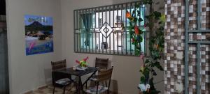 a table and chairs in a room with a window at Casa de temporada SONHO DE ALTER in Alter do Chao